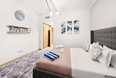 a bedroom with a large bed in a room at Luxury 2BR Burj View with Pool Walk to Mall & Metro Dining Shopping in Dubai