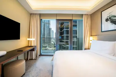 a hotel room with a bed and a desk and a window at NewArabian Opera Address Residences in Dubai