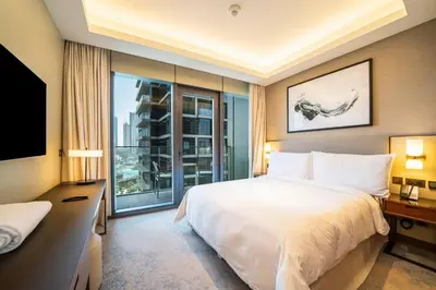 a bedroom with a large bed and a large window at NewArabian Opera Address Residences in Dubai