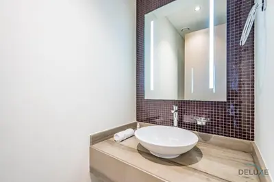 a bathroom with a sink and a mirror at Stylish 1BR in Damac Towers by Paramount B, Business Bay by Deluxe Holiday Homes in Dubai