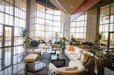 a lobby with a couch and tables and windows at Stylish 1BR in Damac Towers by Paramount B, Business Bay by Deluxe Holiday Homes in Dubai