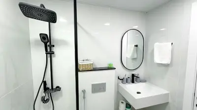 a white bathroom with a shower and a sink at Dubai Marina - Stylish Studio Apartment - Marina Diamond 2 in Dubai