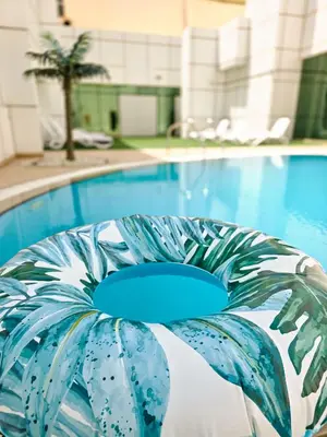 a swimming pool with a blue and white chair next to it at Stylish 1BR Apartment! Near Metro & Stroll to Dubai Marina in Dubai