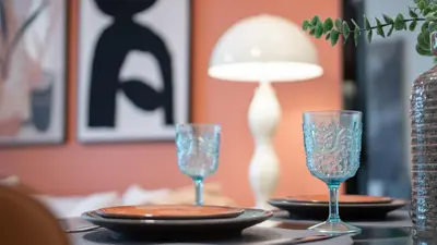 a table with two glasses and a lamp on it at Stylish 1BR Apartment! Near Metro & Stroll to Dubai Marina in Dubai