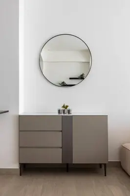 a dressing table with a mirror on a white wall at Studio apartment MeDoRe Tower in Dubai