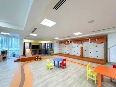 a room with a climbing wall and tables and chairs at Studio apartment MeDoRe Tower in Dubai
