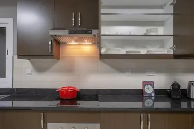 a kitchen with brown cabinets and a red bowl on the counter at Blueground Sheikh Zayed Rd pool gym DXB-462 in Dubai