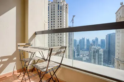 a balcony with two chairs and a table on a building at Blueground Sadaf sea view elevator gym DXB-925 in Dubai
