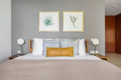 a bedroom with a large bed with two pictures on the wall at Blueground Sadaf sea view elevator gym DXB-925 in Dubai
