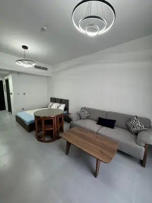 a living room with a couch and a table at Jvc diamond 1 home in Dubai