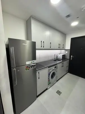 a kitchen with a refrigerator and a washer and dryer at Jvc diamond 1 home in Dubai
