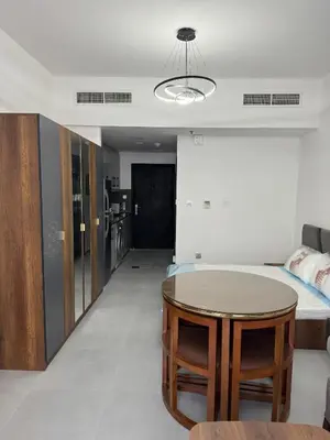 a living room with a table and a bed at Jvc diamond 1 home in Dubai