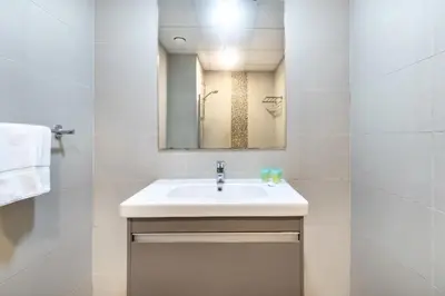 a white bathroom with a sink and a mirror at ShoresInn - Mesmerizing Waterfront in Dubai Marina in Dubai
