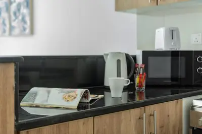 a kitchen counter with a book and a coffee cup at ShoresInn - Mesmerizing Waterfront in Dubai Marina in Dubai