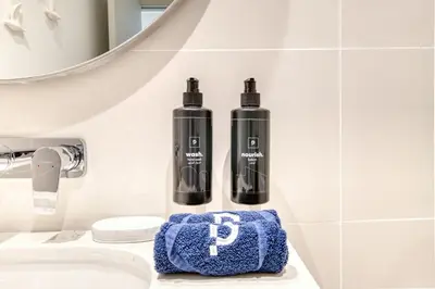 two bottles on a bathroom counter next to a sink at Chic 2BR with Iconic Dubai Eye and Palm Views in Dubai