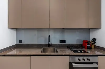 a kitchen with white cabinets and a sink at Waves - Stylish 13th-Floor Studio with Top-Notch Amenities in Dubai