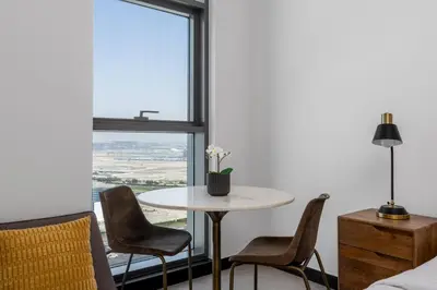 a table and chairs in a room with a window at Waves - Stylish 13th-Floor Studio with Top-Notch Amenities in Dubai