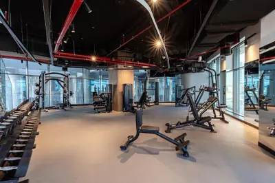 a gym with several treadmills and elliptical machines at Waves - Stylish 13th-Floor Studio with Top-Notch Amenities in Dubai