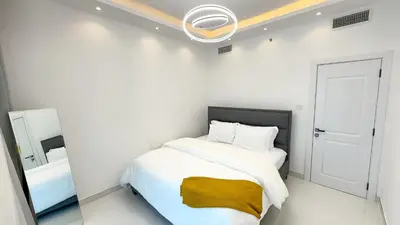 a white bedroom with a bed and a mirror at Dubai Marina - 1 BHK Classy Apartment in Dubai