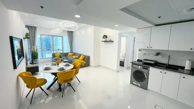 a kitchen and living room with a table and yellow chairs at Dubai Marina - 1 BHK Classy Apartment in Dubai