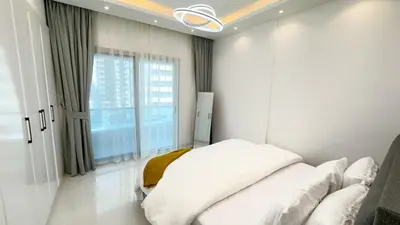 a white bedroom with a bed and a window at Dubai Marina - 1 BHK Classy Apartment in Dubai