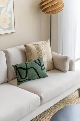 a white couch with a green pillow on it at GuestReady - Luxurious paradise in Dubai in Dubai