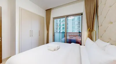 a bedroom with a large white bed and a window at Creek Vistas Reserve - Modern One Bedroom in Dubai