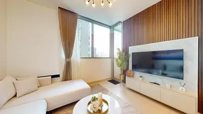 a living room with a white couch and a large television at Creek Vistas Reserve - Modern One Bedroom in Dubai