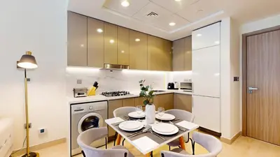a kitchen and dining room with a table and chairs at Azizi Riviera 18 - Neat One Bedroom in Meydan in Dubai