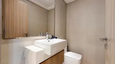 a bathroom with a white sink and a toilet at Azizi Riviera 18 - Neat One Bedroom in Meydan in Dubai