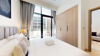 a bedroom with a white bed and a large window at Azizi Riviera 18 - Neat One Bedroom in Meydan in Dubai