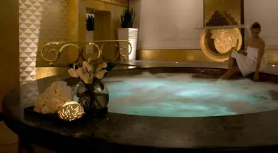 a jacuzzi tub in a room with a person sitting in it at Luxurious Apartment 500 Meters Next to Dubai Mall in Dubai