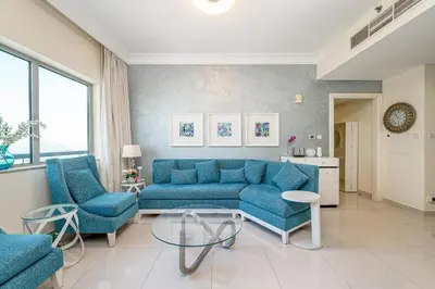 a living room with a blue couch and two chairs at Luxurious Apartment 500 Meters Next to Dubai Mall in Dubai