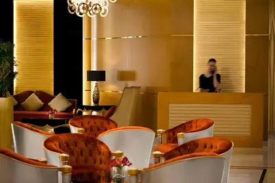 a lobby with chairs and a man in the background at Luxurious Apartment 500 Meters Next to Dubai Mall in Dubai
