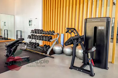 a gym with two exercise bikes and weights at Lux 1BR Direct access to Dubai Marina 4 people in Dubai