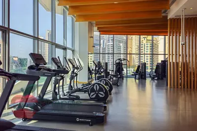 a gym with treadmills and ellipticals in a building at Lux 1BR Direct access to Dubai Marina 4 people in Dubai
