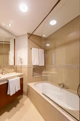 a bathroom with a bath tub and a sink at Dubai Mall Direct Connection Apartment - Burj Vista in Dubai