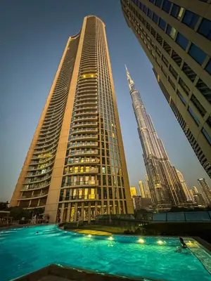 two tall skyscrapers in a city at dusk at Dubai Mall Direct Connection Apartment - Burj Vista in Dubai