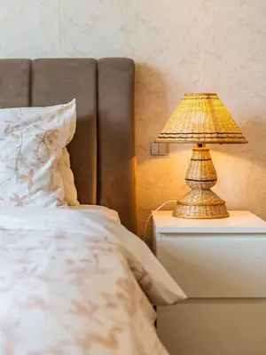 a lamp on a night stand next to a bed at Chic 4BR Apt Pool Palm Beach Club Dubai in Dubai