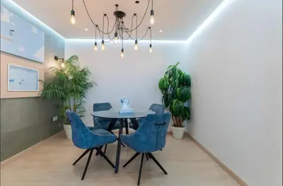 a dining room with a table and blue chairs at AWS Holiday Homes - Spectacular Sea Views in Dubai