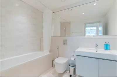 a white bathroom with a toilet and a sink at AWS Holiday Homes - Memories by the Beach in Dubai