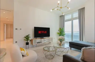 a living room with a tv and a couch at AWS Holiday Homes - Memories by the Beach in Dubai