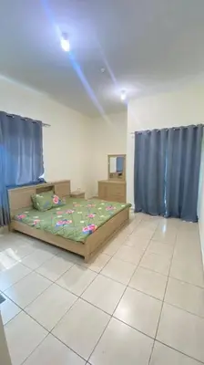 a bedroom with a bed and blue curtains at Furnished Apartment in Silicon Oasis on Prime Location in Dubai