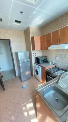 a kitchen with a stainless steel refrigerator and a sink at Furnished Apartment in Silicon Oasis on Prime Location in Dubai