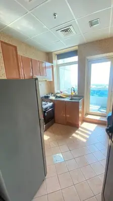 a kitchen with a sink and a refrigerator at Furnished Apartment in Silicon Oasis on Prime Location in Dubai