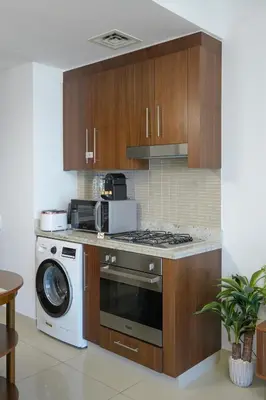 a kitchen with a stove and a washing machine at CH Urban Haven - 1BR at Boulevard Point with Burj & Fountain Views in Dubai