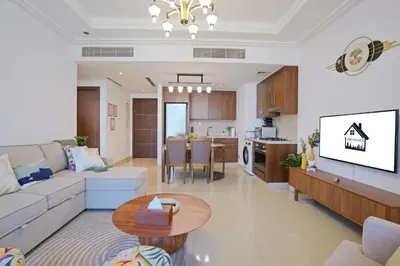 a living room and kitchen with a couch and a table at CH Urban Haven - 1BR at Boulevard Point with Burj & Fountain Views in Dubai