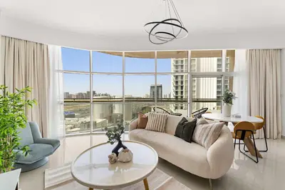 a living room with a couch and a large window at Silkhaus Modern Studio in Reef Residence at JVC in Dubai