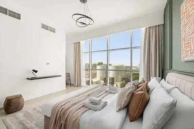a bedroom with a large bed with a large window at Silkhaus Modern Studio in Reef Residence at JVC in Dubai