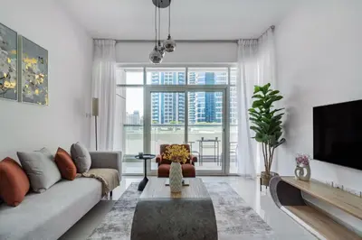 a living room with a couch and a tv at ShoresInn - Artistic Retreat in Dubai Marina in Dubai